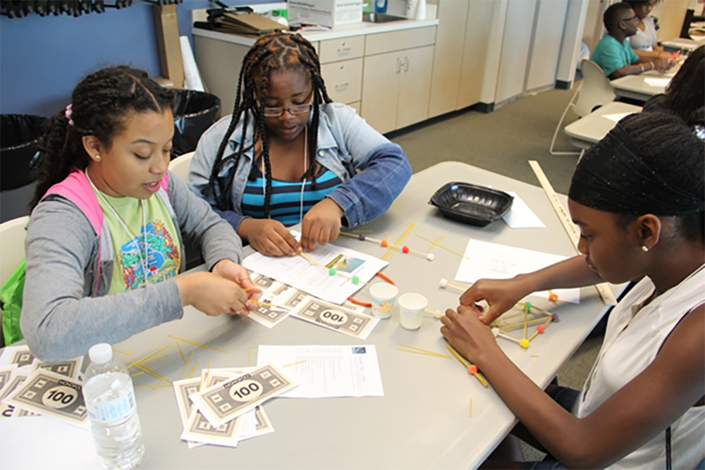 Three students participate in hands-on learning activity.