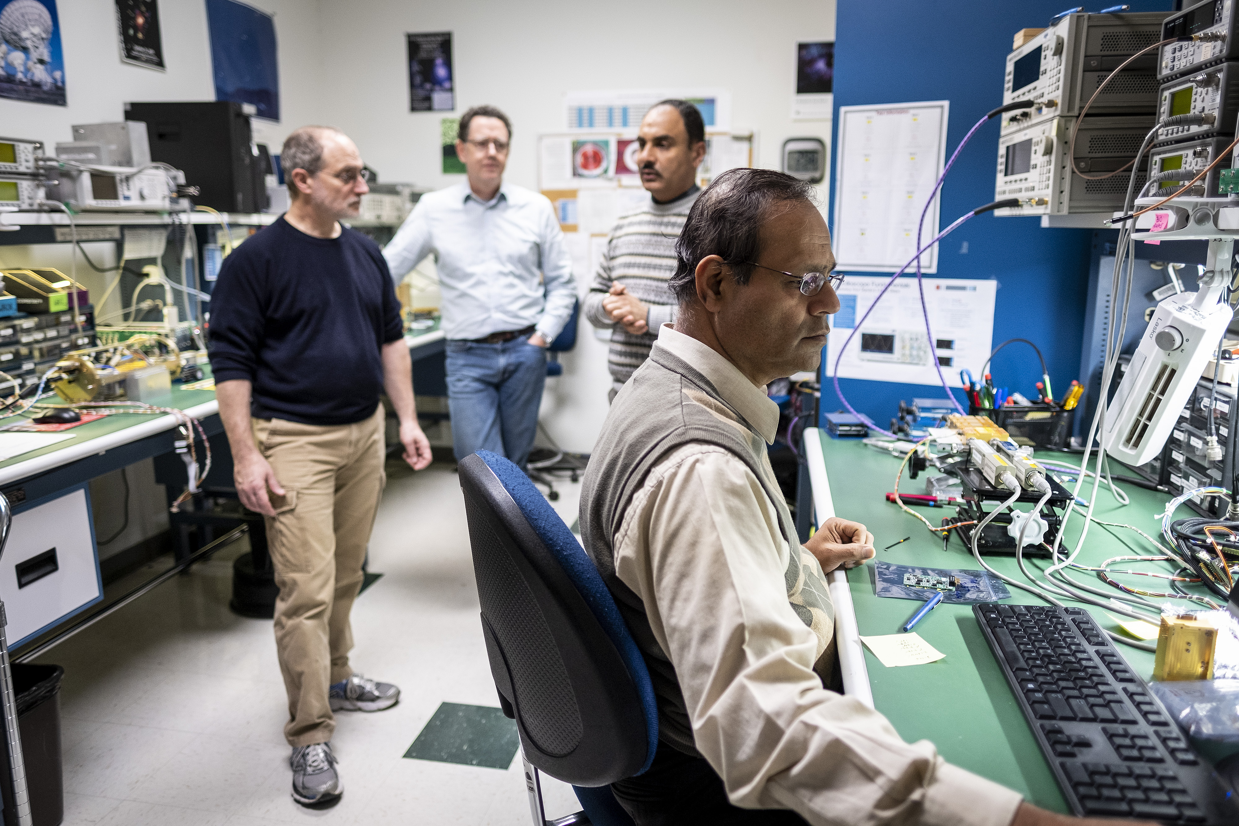 Four scientists converse in a lab
