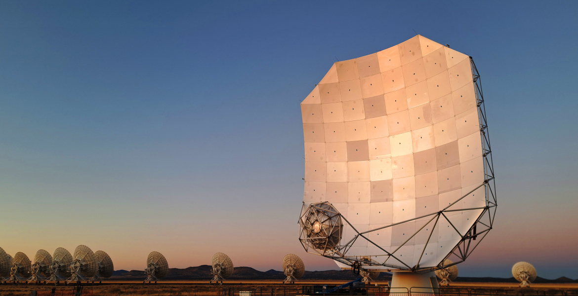 The sun sets behind the antenna of the ngVLA