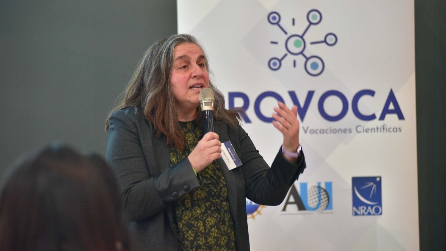 Sonia Duffau speaks into a mic standing infrom of a PROVOCA pop up banner.